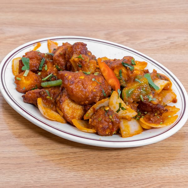 Chili Paneer from Vatica Indian Cuisine, with paneer, onions, peppers, and cilantro in a spicy sauce.